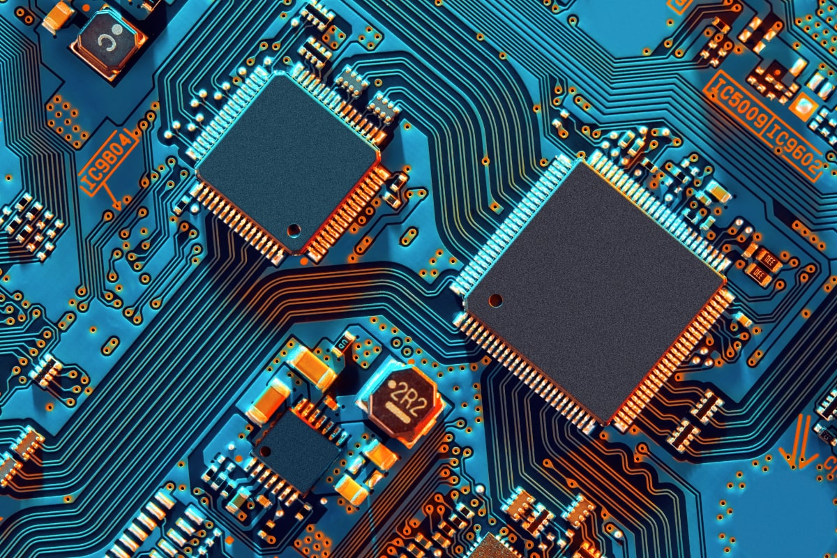 Close-up of a blue circuit board with microchips and electronic components.